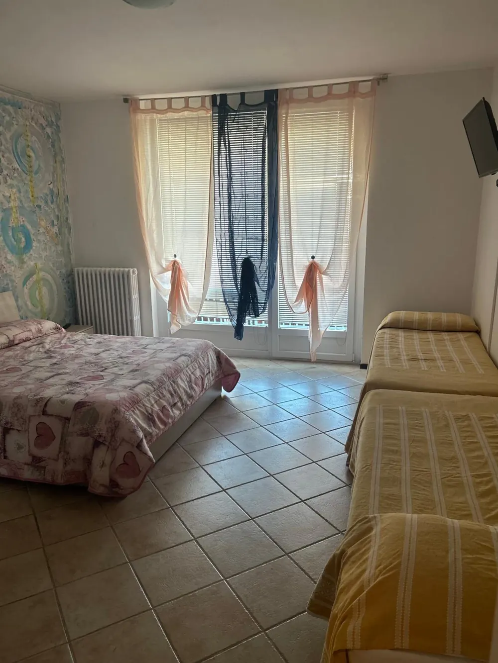 Camera per quattro rinnovata, con il letto matrimoniale, due letti singoli e la portafinestra luminosa
