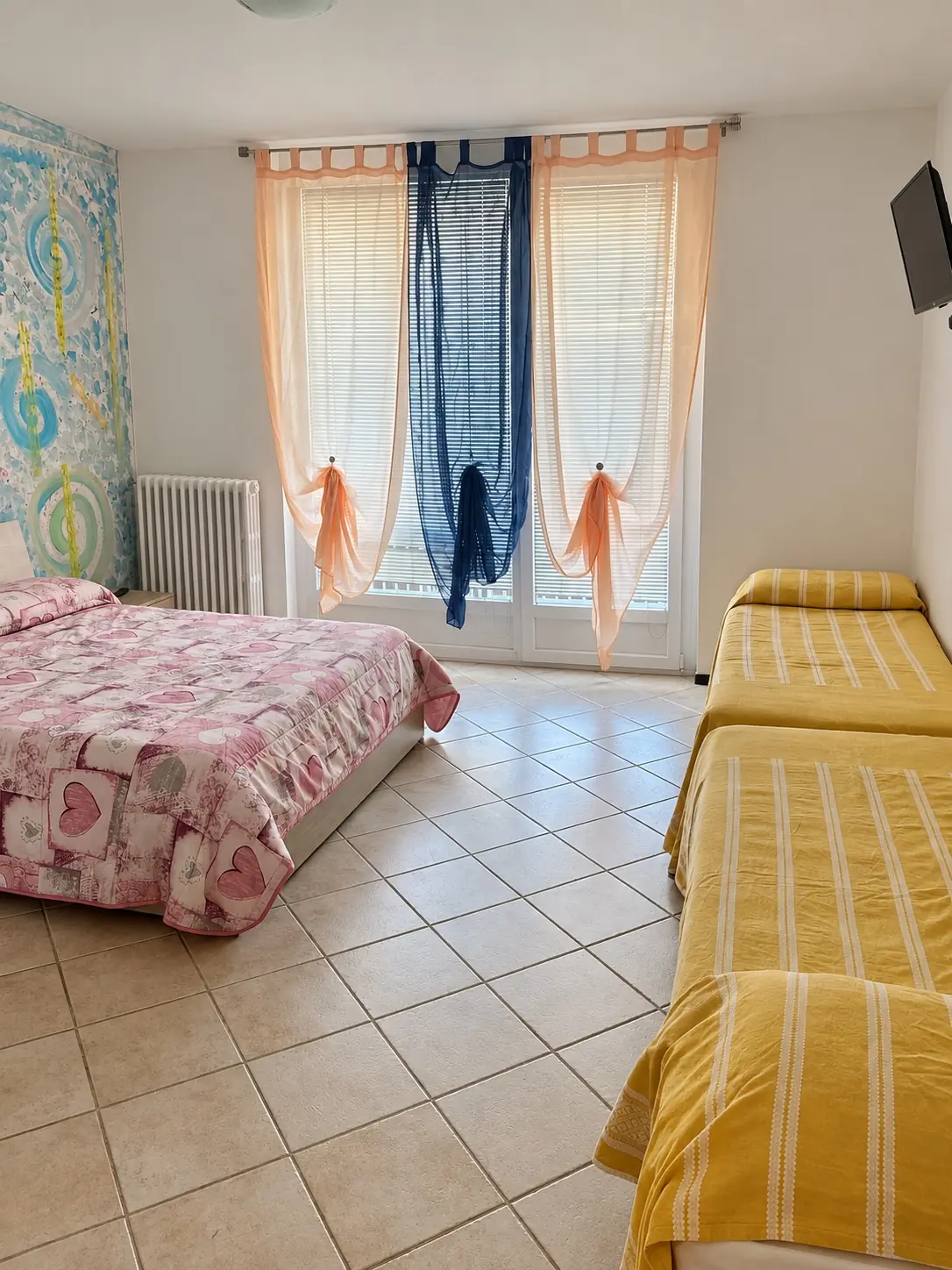 Camera per quattro, con il letto matrimoniale, due letti singoli e la portafinestra luminosa