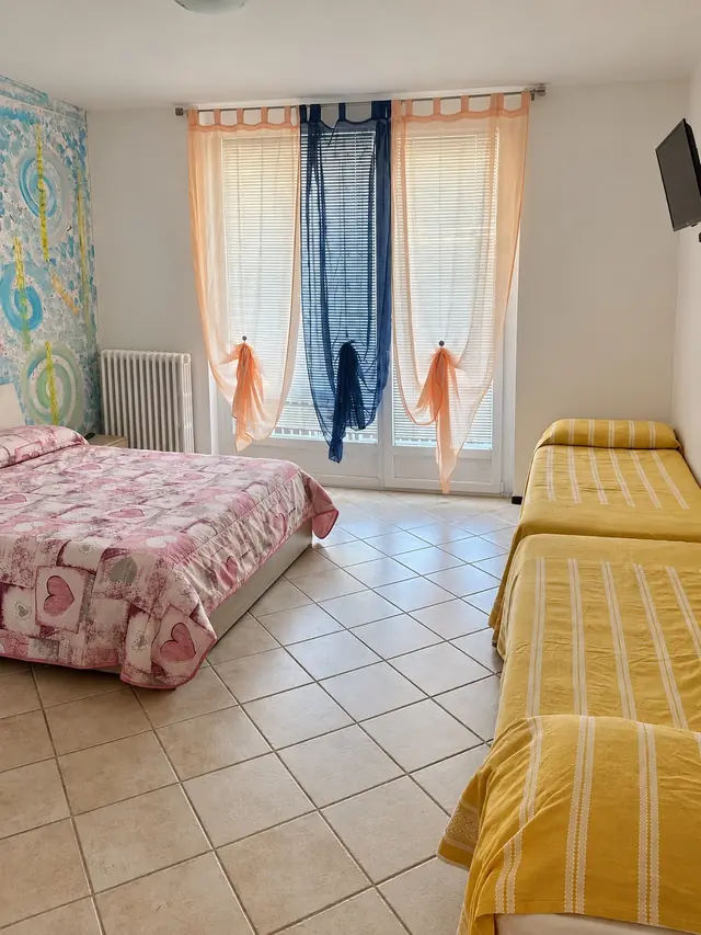 Camera per quattro, con il letto matrimoniale, due letti singoli e la portafinestra luminosa