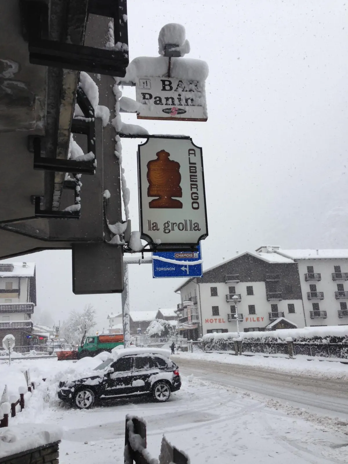 L'insegna dell'Albergo La Grolla, con la grolla disegnata, sotto la nevicata sulla strada di Filey