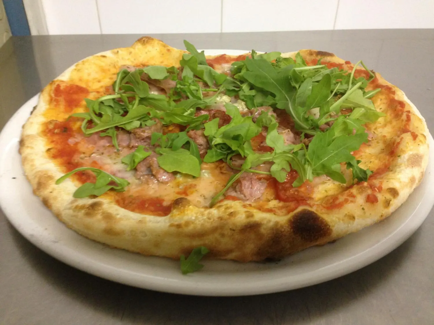 Pizza con pomodoro, mozzarella, bresaola e rucola fresca